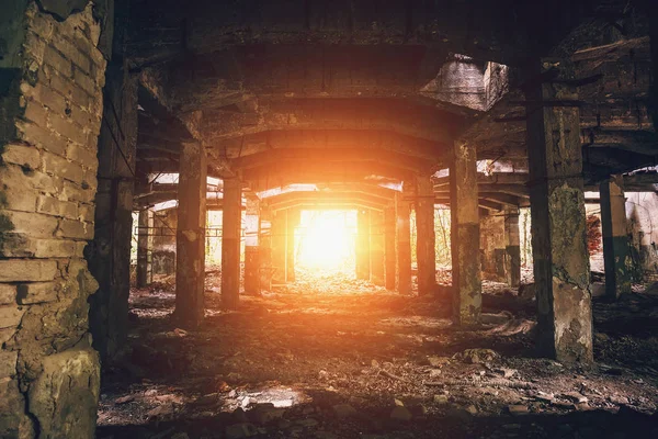 Almacén abandonado con columnas, perspectiva de túnel oscuro con luz brillante al final — Foto de Stock