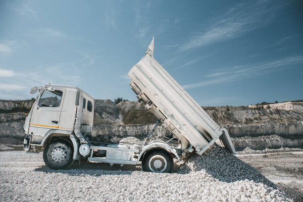 Truck unloads white limestone gravel to crushed stone quarry