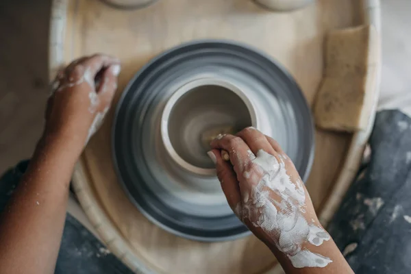 Top view of potter woman hands works at pottery wheel, potter makes new ceramic production — Stock Photo, Image