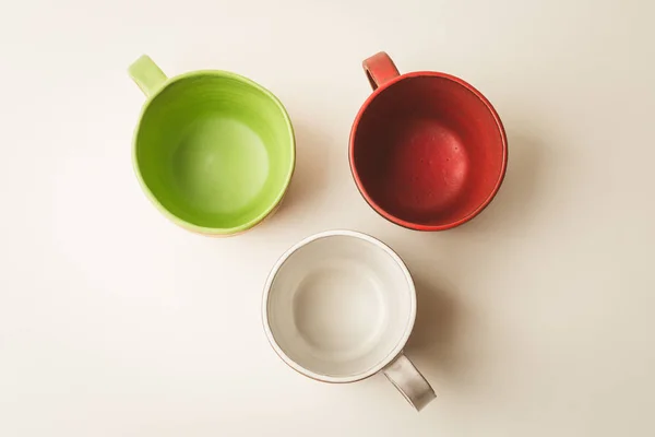 흰색 바탕에 3 개의 다채로운 손수 빈 컵 이나 머그컵의 상위 뷰 — 스톡 사진
