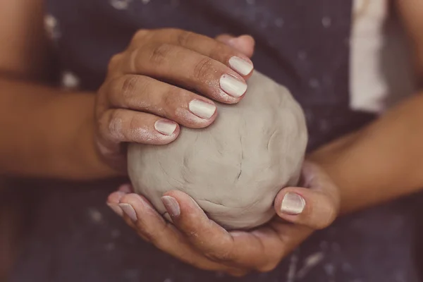 Mãos de oleiro fêmea mantém a argila para cerâmica, foco seletivo — Fotografia de Stock