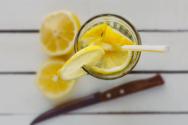 Cam ile üstten görünüm müstahkem su ile ahşap masa üzerinde limon detoks. Sağlıklı detoks içecek