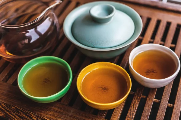 Conjunto de chá asiático na placa de chá de madeira, pialas coloridas ou tigelas de chá, gaiwan — Fotografia de Stock