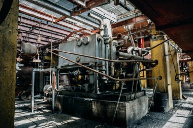 İçinde terkedilmiş fabrikada metal paslı ekipman ve aletler