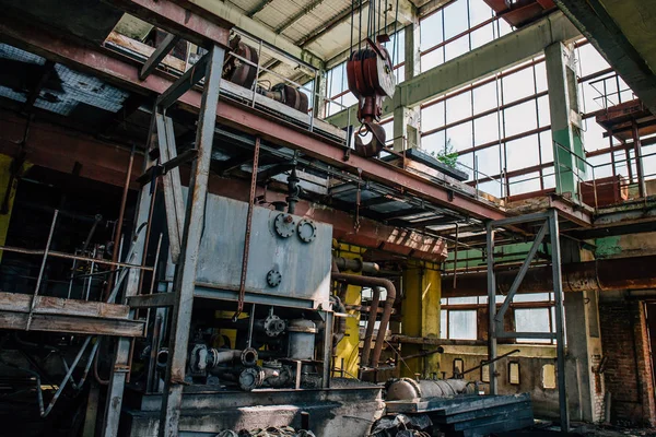 Övergiven fabrik släpper interiör med utrustning, järn riggar, rör — Stockfoto