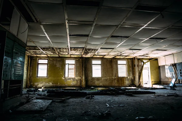 Large ruined room with windows, control center room in abandoned factory — Stock Photo, Image