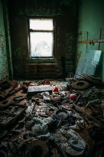 Donkere vuile kamer met vuilnis in een verlaten industrieel gebouw, afgezwakt — Stockfoto