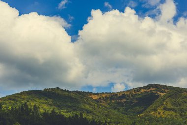 Yeşil dağlar ve beyaz kabarık bulutlar