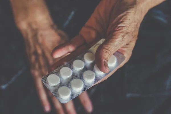 Opakowania z pigułki lub tabletki w rękach starszą kobietę — Zdjęcie stockowe