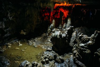 Stalagmites inside a large underground cave clipart
