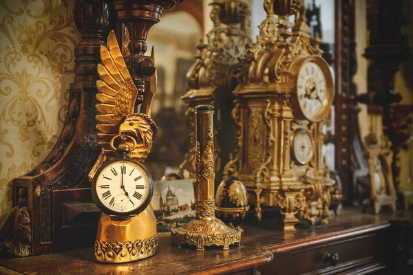 Старий старовинний бронзовий годинник і посуд на дерев'яній полиці — стокове фото