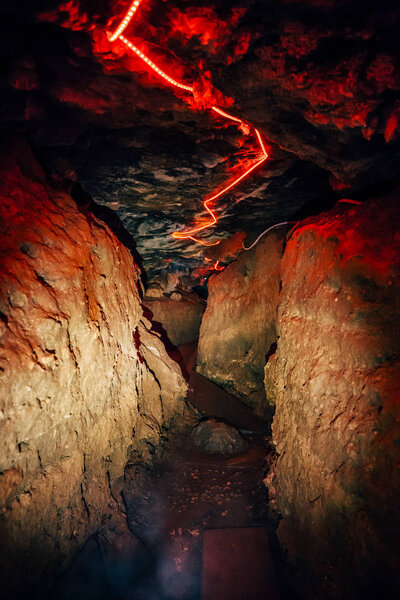 Тоннель, вырезанный на известняке с красным светом на полу
