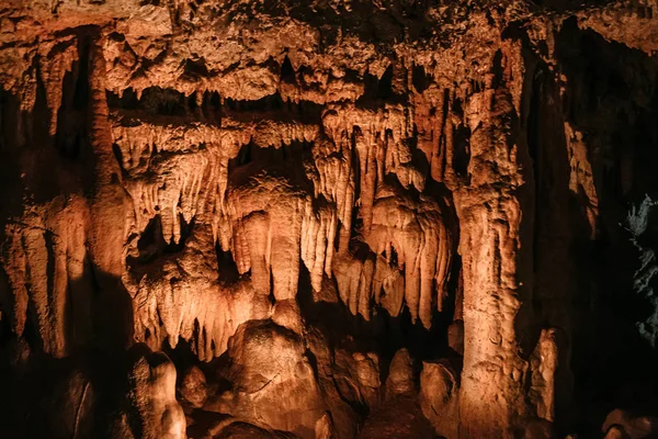 Stalaktity a stalagmity v podzemní jeskyni s dramatickým podsvícení — Stock fotografie