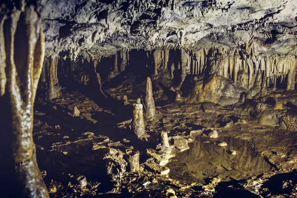 Estalactitas y estalagmitas en una oscura cueva subterránea —  Fotos de Stock
