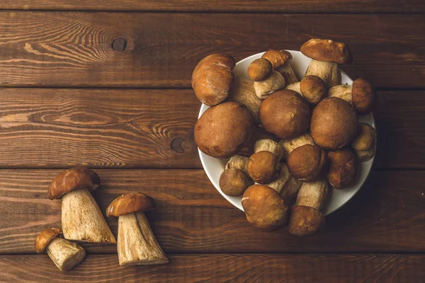 Mantar arka plan, ahşap masa üzerinde bir tabak içinde mantar Üstten Görünüm