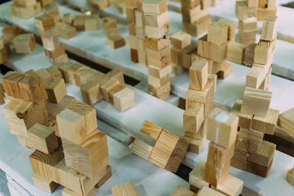 Muchas torres hechas de cubos de madera en una mesa de madera blanca, pasatiempos, juegos educativos para niños — Foto de Stock