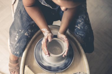 Potter's tekerlek üzerinde çalışan genç kadın potter