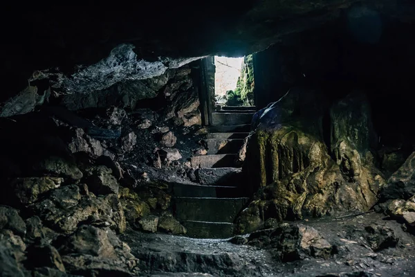 Cueva oscura con escalones de escalera y luz de entrada —  Fotos de Stock