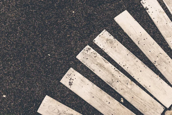 Weiße Holzplanken auf einer flachen Oberfläche aus schwarzem Stein, Draufsicht — Stockfoto