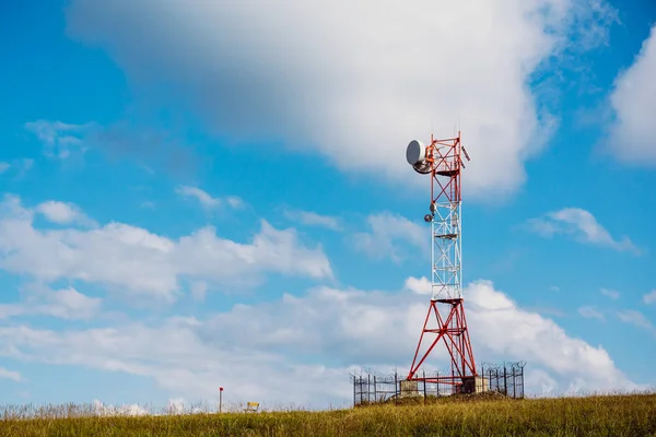 Torre de comunicação para comunicações móveis e antenas de TV na montanha no fundo do céu azul — Fotografia de Stock