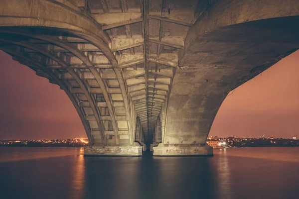 Vista bajo el puente Vogresovsky a través del río Voronezh por la noche, paisaje urbano oscuro — Foto de Stock