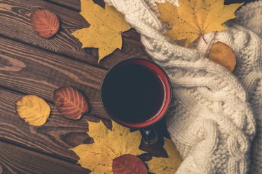 Sonbahar, sarı ve turuncu sonbahar yaprakları, çay fincan sıcak, ahşap rustik zemin üzerine sıcak eşarp