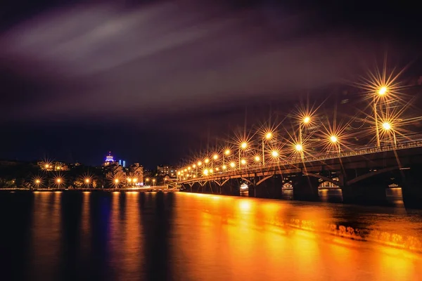Beleuchtete Tschernawsky-Brücke bei Nacht, Blick auf rechtes Ufer oder Innenstadt der Stadt Woronesch, dramatisches Stadtbild mit Spiegelung — Stockfoto