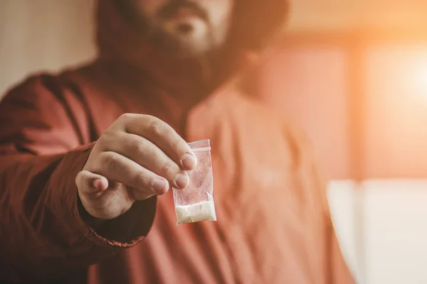 Mann mit Kokainpuder in Plastiktüte in der Hand, selektiver Fokus. Drogendealer verkauft Drogen — Stockfoto