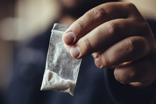 Ο άνθρωπος χέρι κρατά πλαστικό πακέτο ή τσάντα με κοκαΐνη ή άλλο φάρμακο, κατάχρηση ναρκωτικών και εθισμό σε κινδύνους έννοια — Φωτογραφία Αρχείου