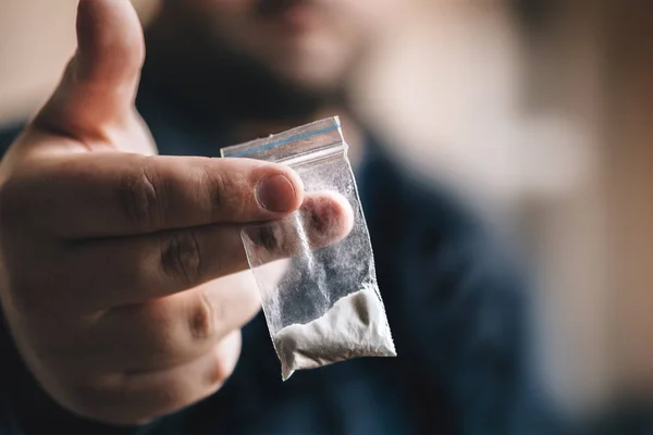 Pengedar narkoba menawarkan dosis kokain atau obat lain dalam kantong plastik, kecanduan obat pada konsep partai Stok Gambar Bebas Royalti
