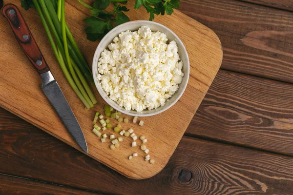 Вид зверху сиру в мисці і зеленій траві на обробній дошці як інгредієнти для домашнього здорового харчування — стокове фото