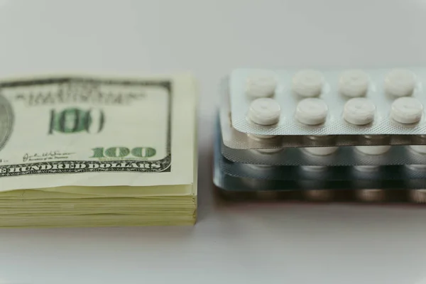 Κόστος της υγειονομικής περίθαλψης, ακριβό ιατρική θεραπεία έννοια. Πακέτο των αμερικανικών δολαρίων και συσκευασία των φαρμάκων — Φωτογραφία Αρχείου