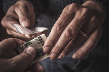 Doz kokain ya da kahraman ya da başka bir narkotik uyuşturucu satıcısından satın para ile bağımlısı adamın elini. Uyuşturucu kullanımı ve trafik