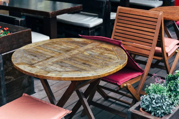 Round wooden table and chairs in a street cafe — Stock Photo, Image