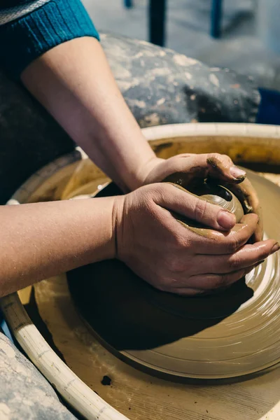 Las manos de mujer trabajan con arcilla en el volante de cerámica. Concepto de rueda de cerámica —  Fotos de Stock