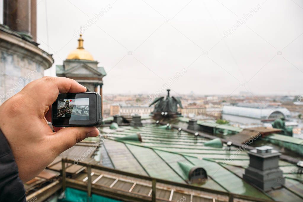 Tourist shoots video on action camera roof of St. Isaac's Cathedral in St. Petersburg