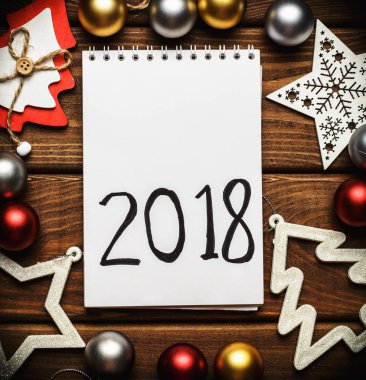 Antika ahşap masa üstünde 2018 el yazısı metin, alay etmek yukarıya veya boş defter ile Noel ve yeni yıl kartı