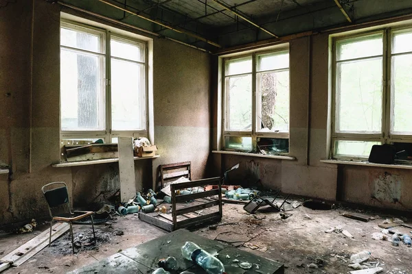 Kamer met grote ramen en meubels in oude geruïneerd verlaten gebouw — Stockfoto