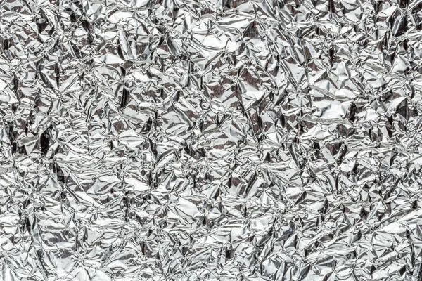 Crumpled shiny metal foil texture or background — Stock Photo, Image