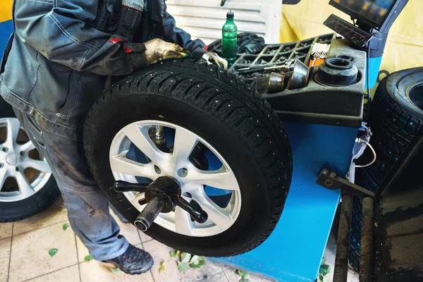 Trabajador mecánico hace equilibrio de rueda de nivel de computadora en equipo especial máquina herramienta en servicio de reparación —  Fotos de Stock