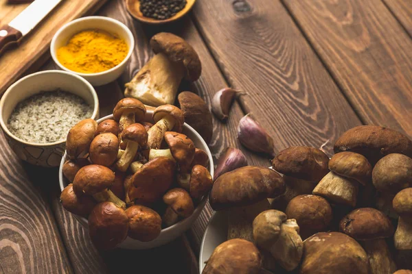 Ingrediënten voor champignonsoep op een houten tafel, twee soorten paddestoelen, specerijen — Stockfoto