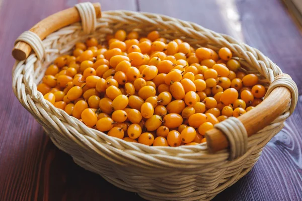 Mar-buckthorn recentemente rasgado em um pote de madeira em um fundo de madeira — Fotografia de Stock