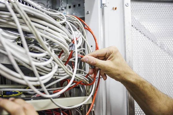 I tecnici commutano il cavo ottico di dati nella stanza del server della rete, hardware di tecnologia del Internet — Foto Stock