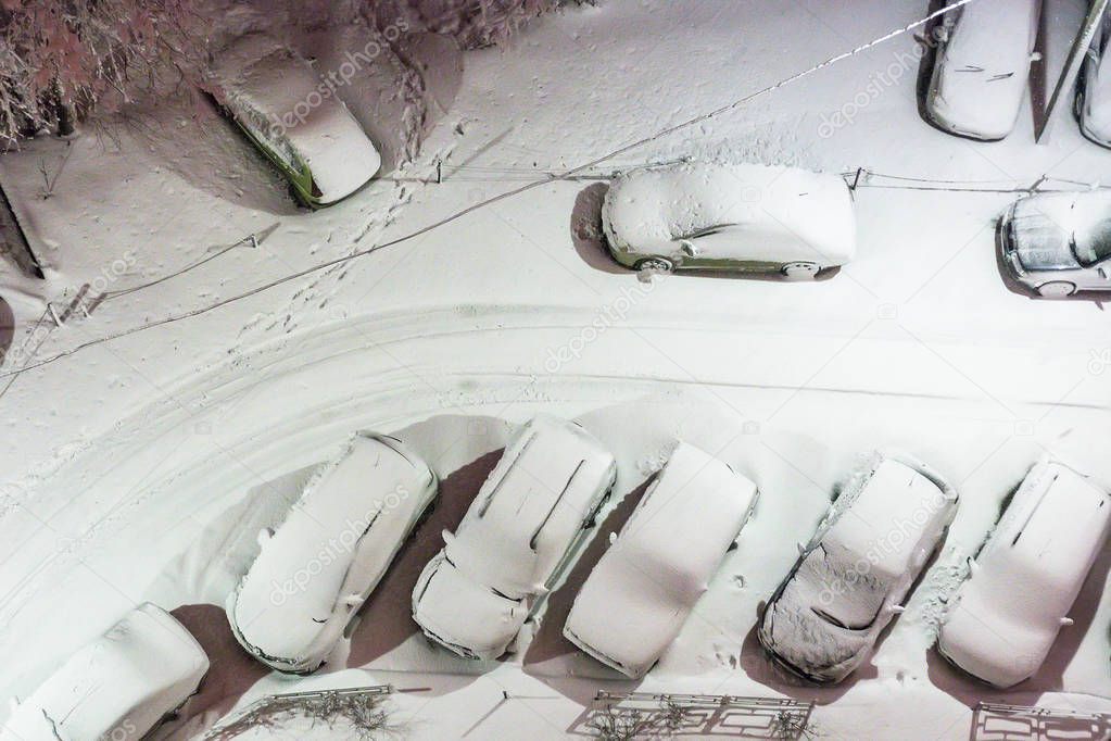 Top view of street car parking in snow at night
