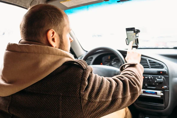 Driver man di mobil menyentuh oleh layar smartphone tangan dengan sistem navigasi aplikasi — Stok Foto