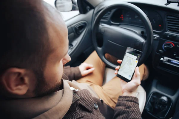 Sopir pria memegang ponsel dengan aplikasi gps di mobilnya, internet modern dan teknologi navigasi untuk bepergian dan mengemudi konsep — Stok Foto
