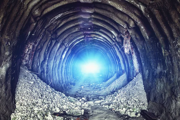 Misteriosa luz azul en el final del antiguo túnel industrial redondo o corredor de minas subterráneas. Escapar y salir al concepto de libertad y esperanza — Foto de Stock
