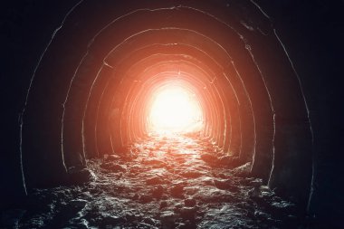 Mysterious light in the end of tunnel. Escape and exit to freedom and hope concept. Abandoned industrial corridor in chalk mine clipart