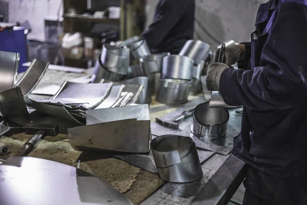 Pekerja membuat bagian-bagian logam untuk produksi sistem udara ventilasi baja industri, pabrik pembuatan logam modern, menutup lokakarya dengan peralatan — Stok Foto