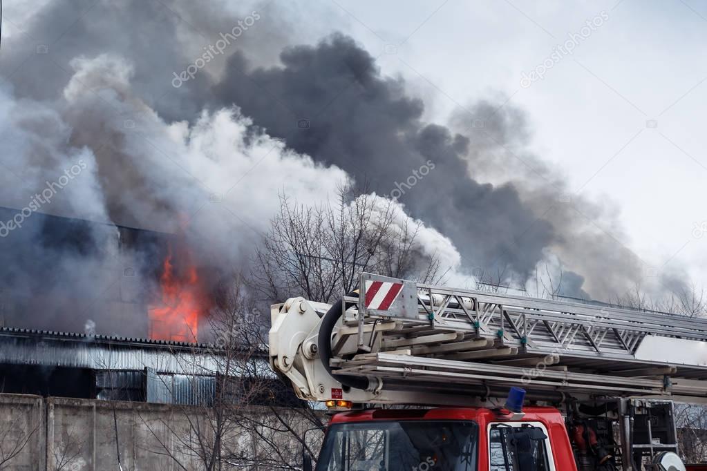 Fire and strong smoke in burning industrial building